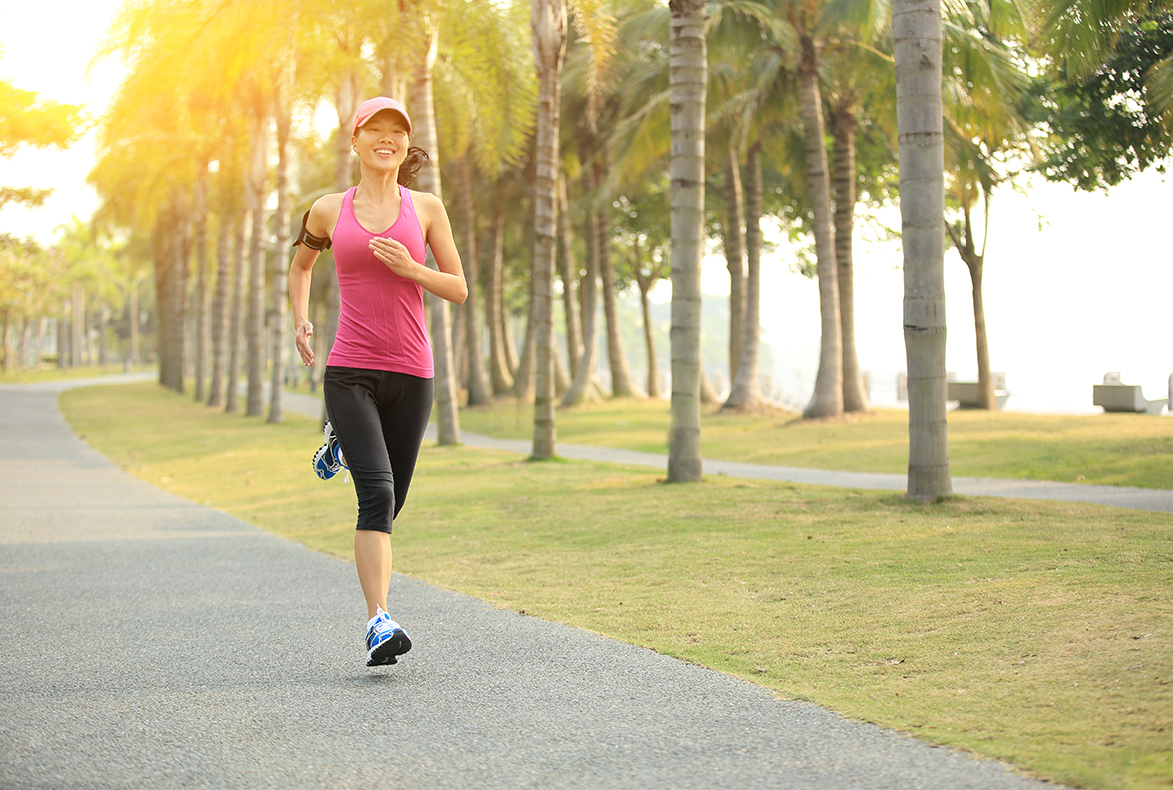 eine Frau im Sonnenlicht am joggen