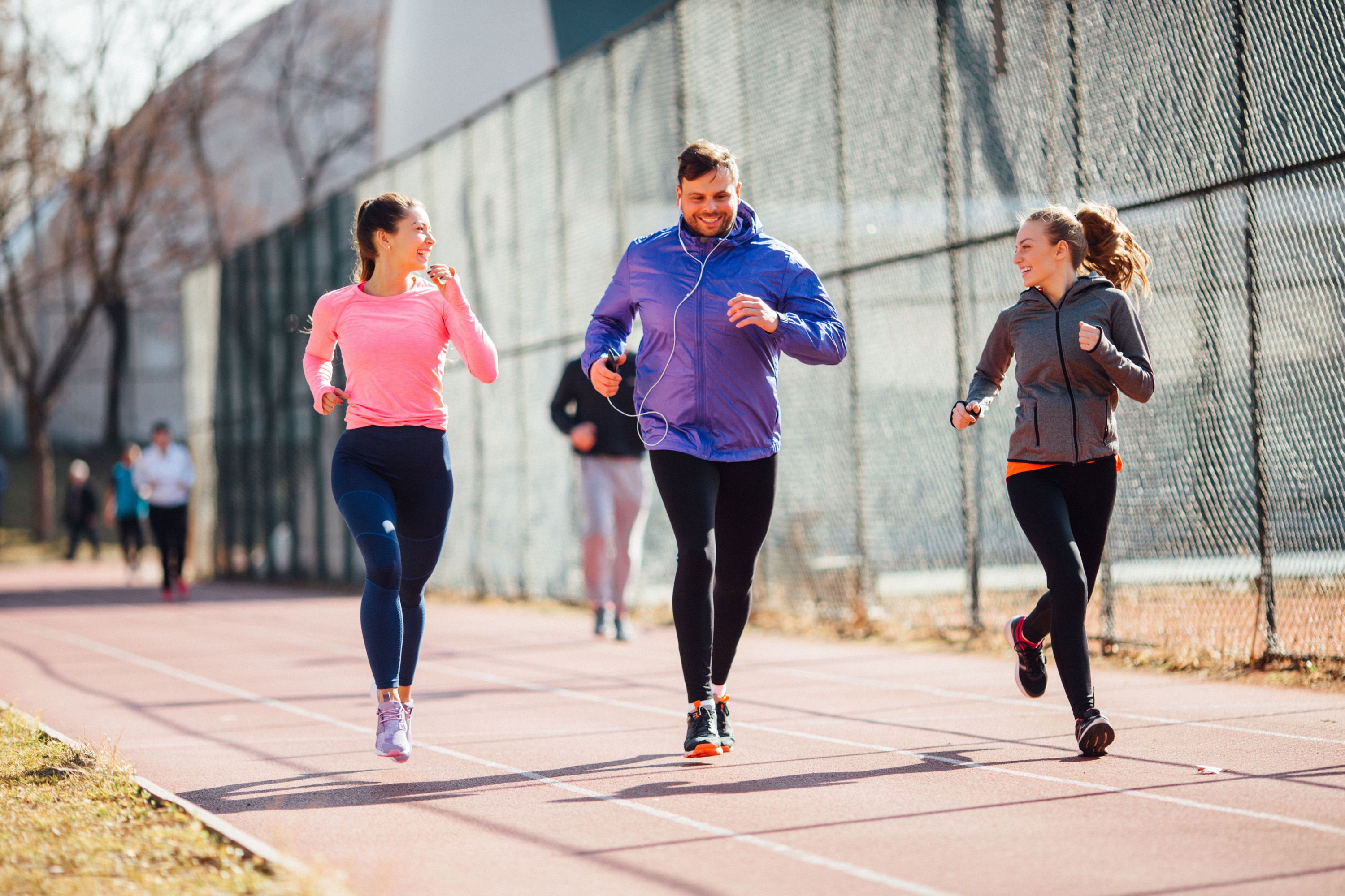 zwei Frauen mit einem Mann am joggen